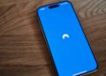 A blue phone sitting on top of a wooden table