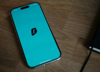 A cell phone sitting on top of a wooden table